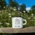 White Campfire Enamel Mug Mockup with Daisy Field.